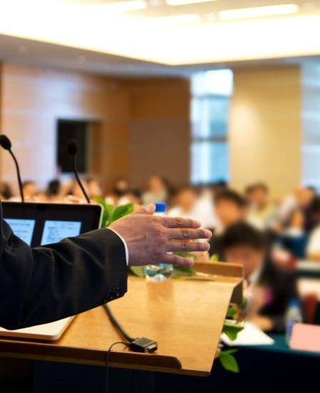 A speaker talking in front of a crowd