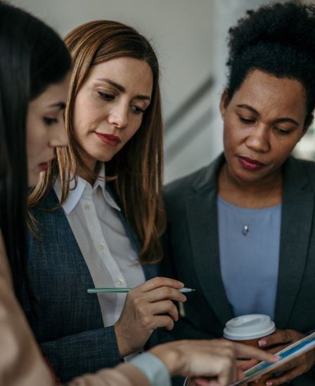 Three women reviewing something on an tablet